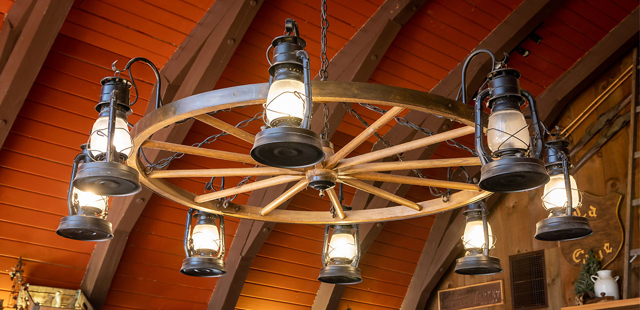 Overhead light in the dining area made of a wagon wheel and lanterns